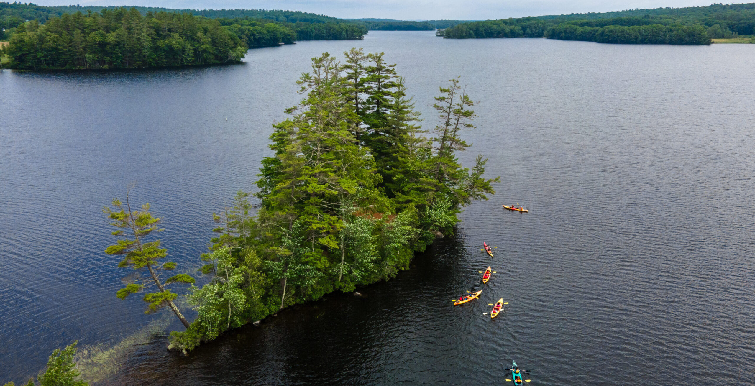 Students explore islands in a bay in their kayaks.