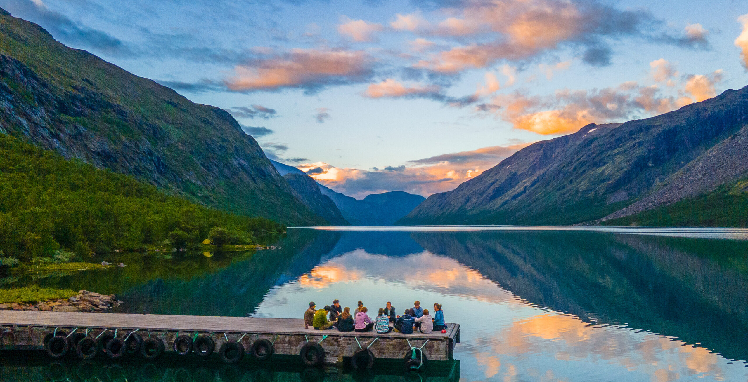 Groups enjoy time together beside beautiful lakes and mountains.