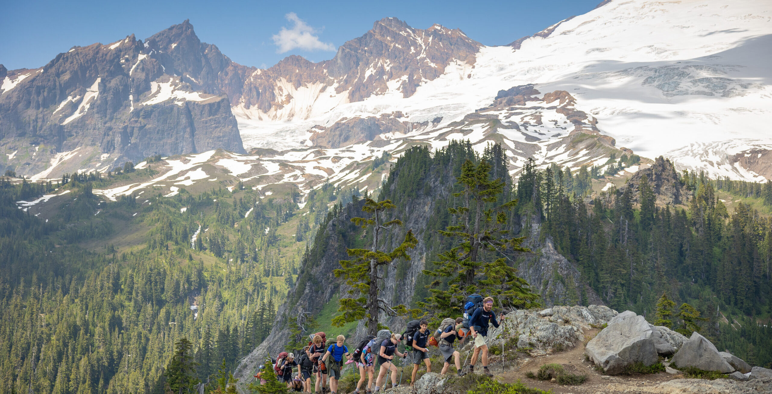 Students hike and enjoy beautiful snow stopped peaks.