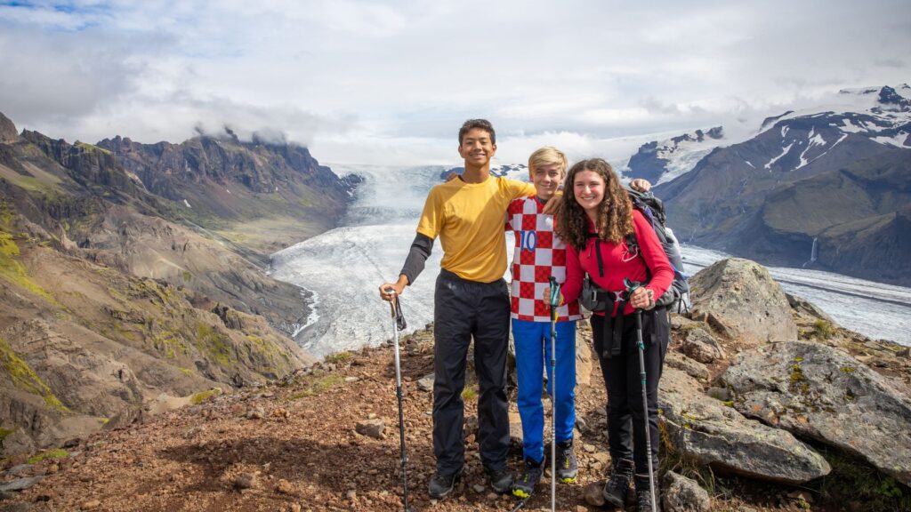 Teen campers standing on a mountain ridge during a scenic hiking trip, showcasing adventure options when selecting the right summer camp.
