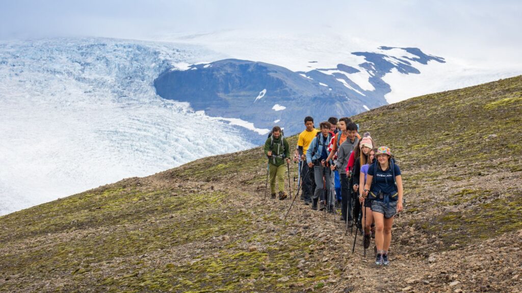 Teens on a guided hike through glacier terrain, part of Overland’s Summer Travel Programs for Teens focused on challenge and adventure.