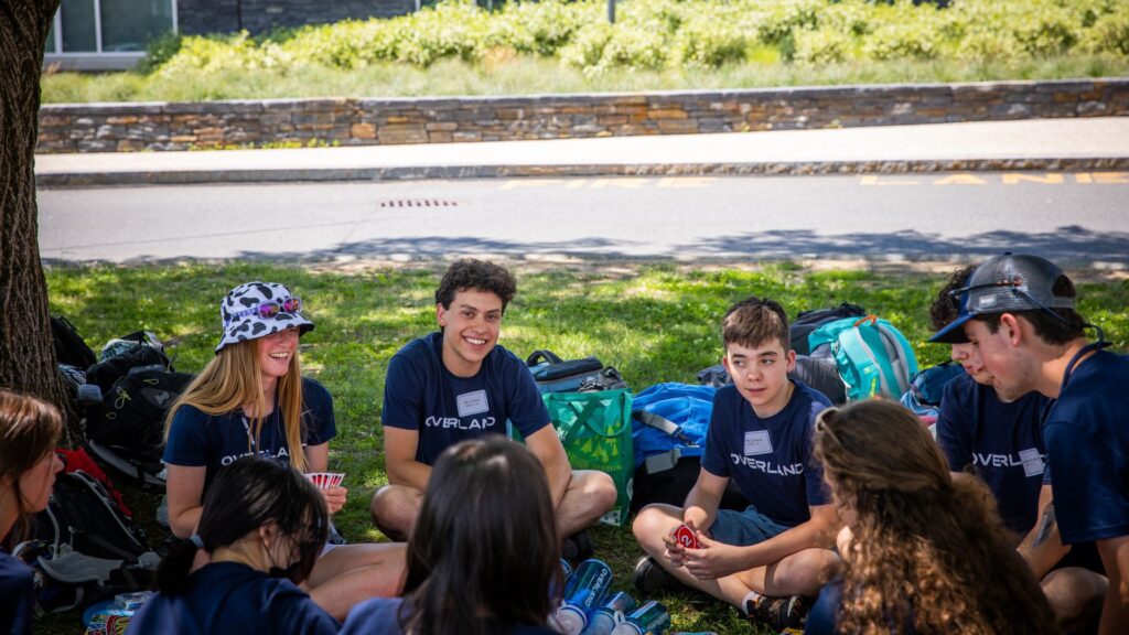 Campers sitting in a circle and laughing during a group activity, reflecting how to choose a summer camp based on your child’s personality and interests.