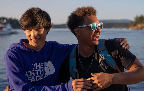 Teens on a youth adventure camp hiking trip smiling