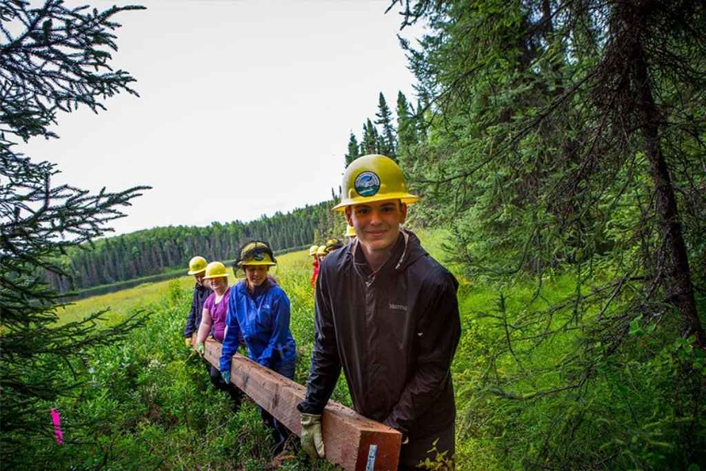Campers developing leadership skills through teamwork on a wilderness service project.