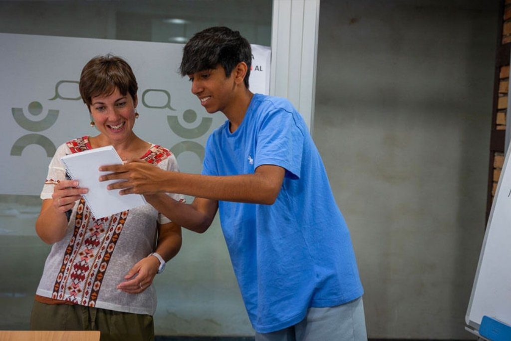 Camper showcasing a creative project with mentor guidance during a summer learning program.