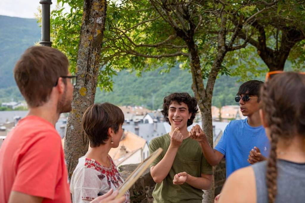 Campers practicing communication skills during a group discussion in an outdoor setting.