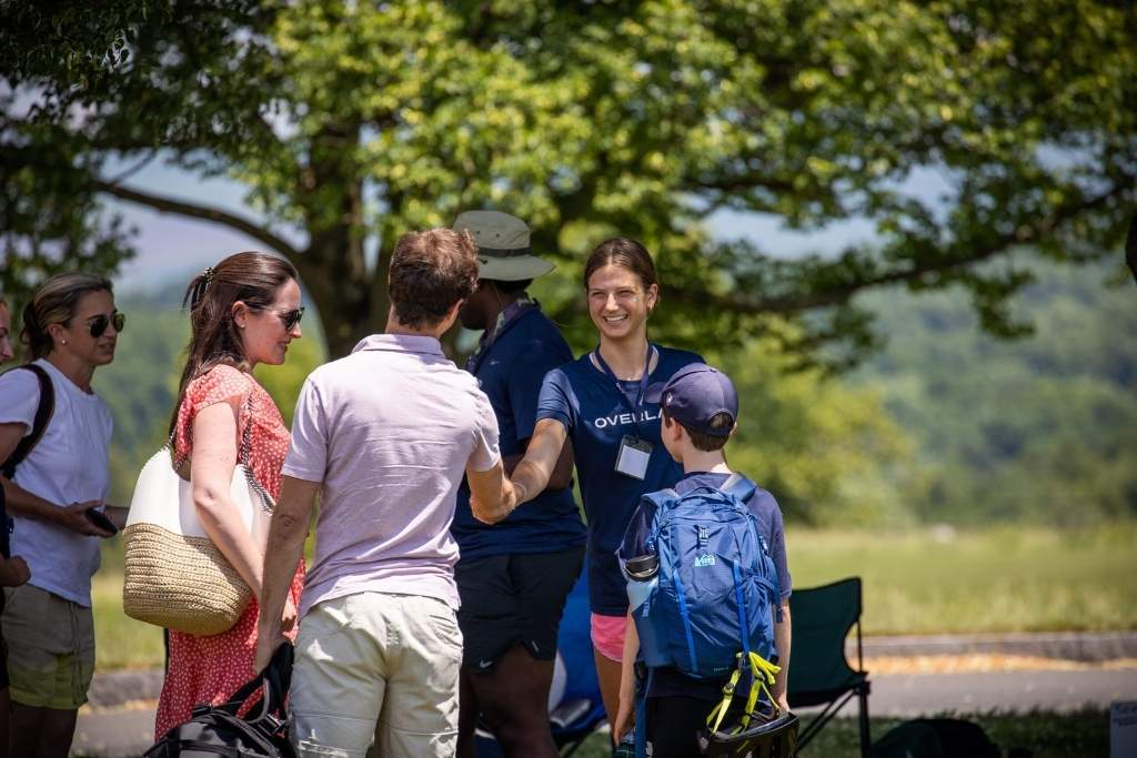 Overland leader greeting a camper and family at summer camp arrival