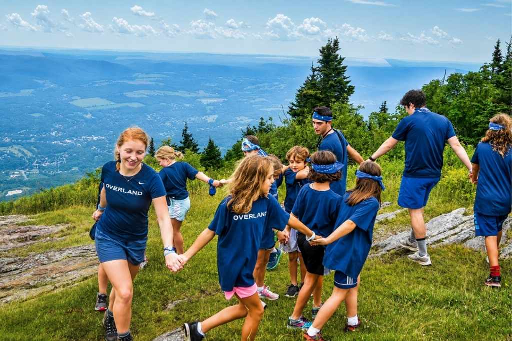 Overland campers hiking together during a group summer camp activity