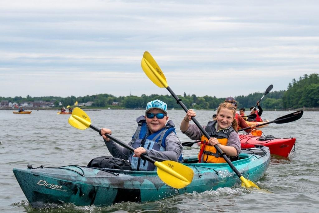 Overland campers kayaking together during an outdoor adventure camp activity