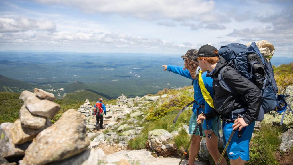 Summer camp campers backpacking on a mountain trail during an outdoor adventure