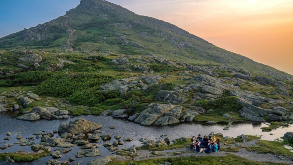 Teens gathered beside an alpine pond during the Appalachian Trail Expedition