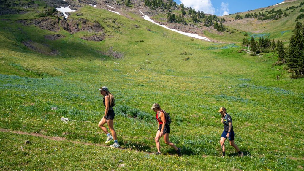 Teens hiking through a mountain meadow during Environmental Stewardship Montana